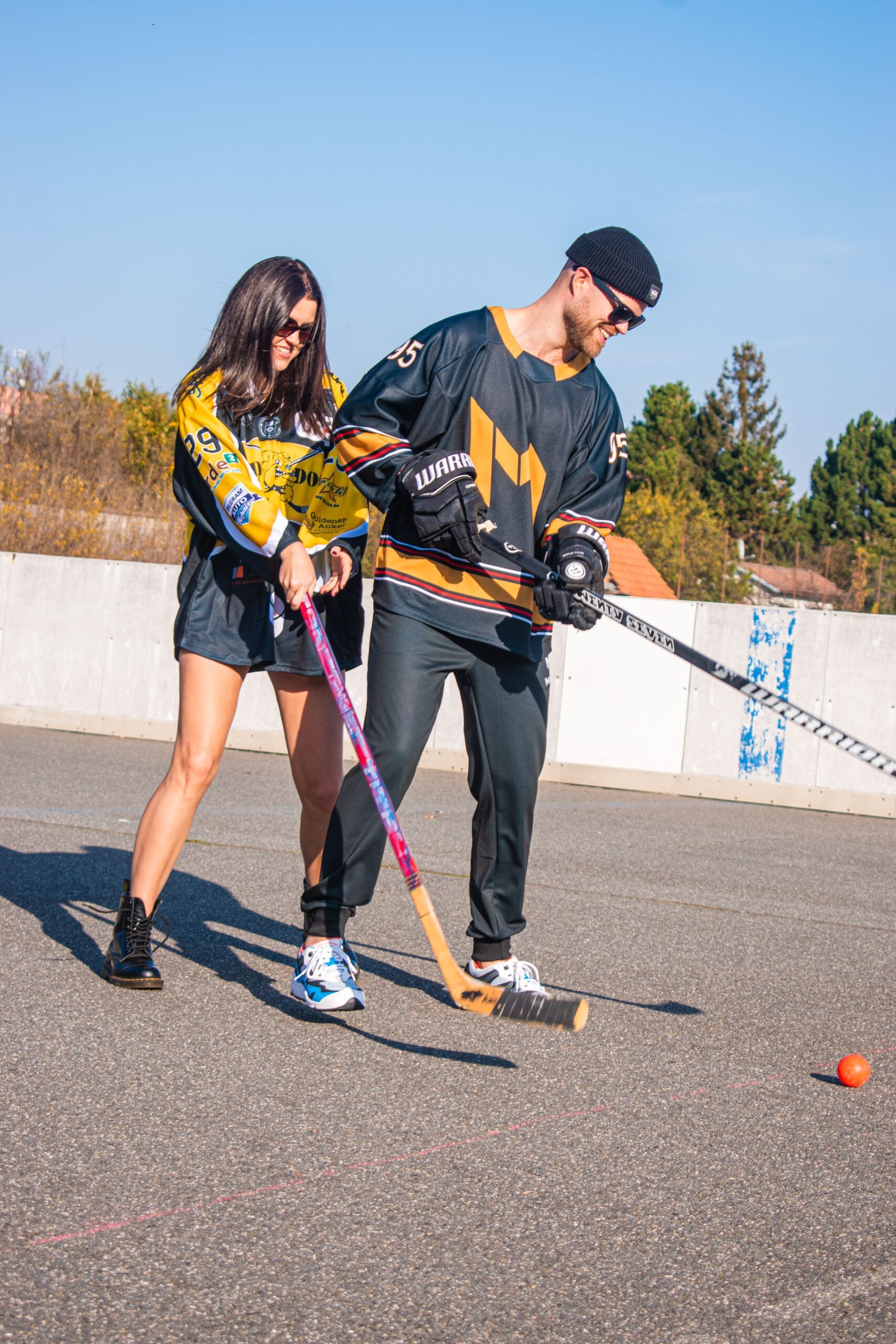 Muž a žena v dresech s potiskem hrají hokejbal